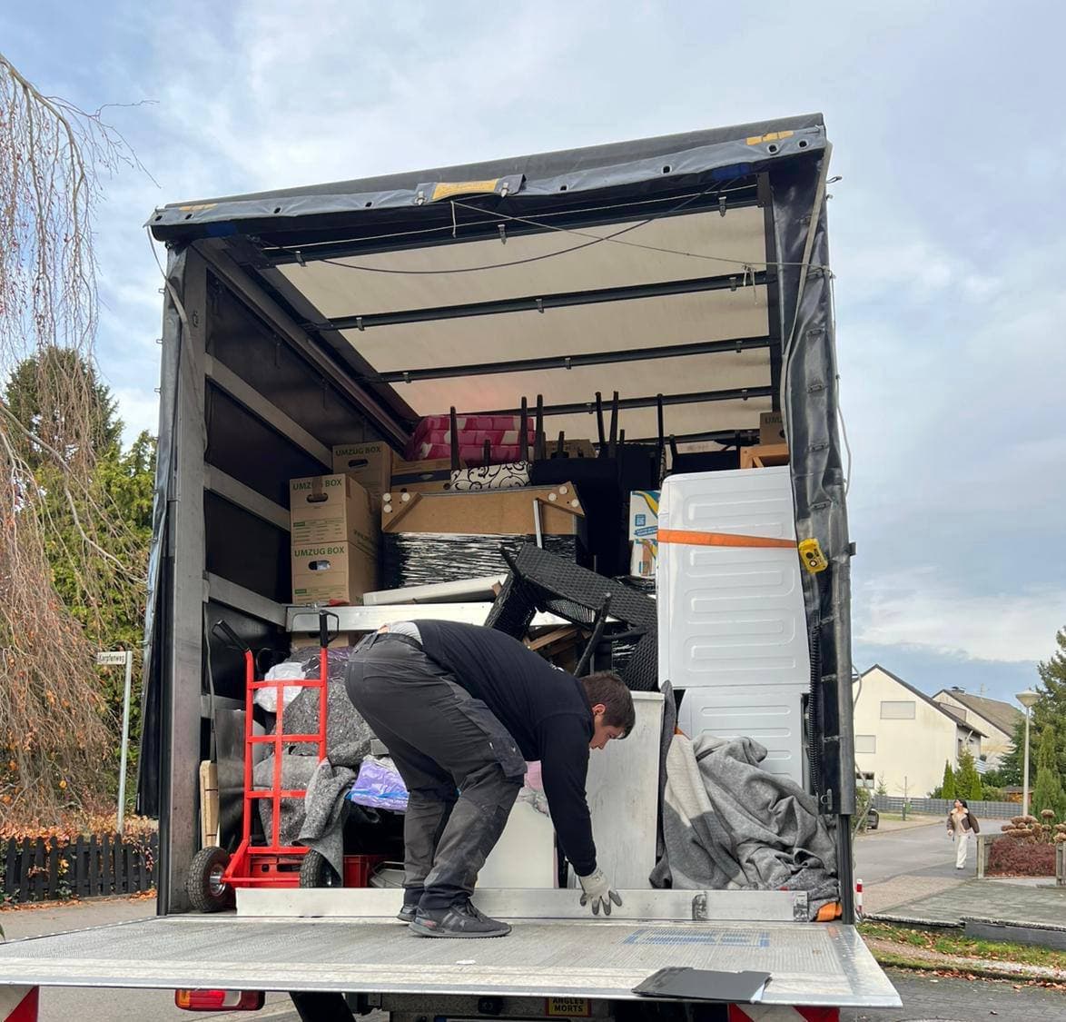 Mitarbeiter lädt Hausrat in den Transporter