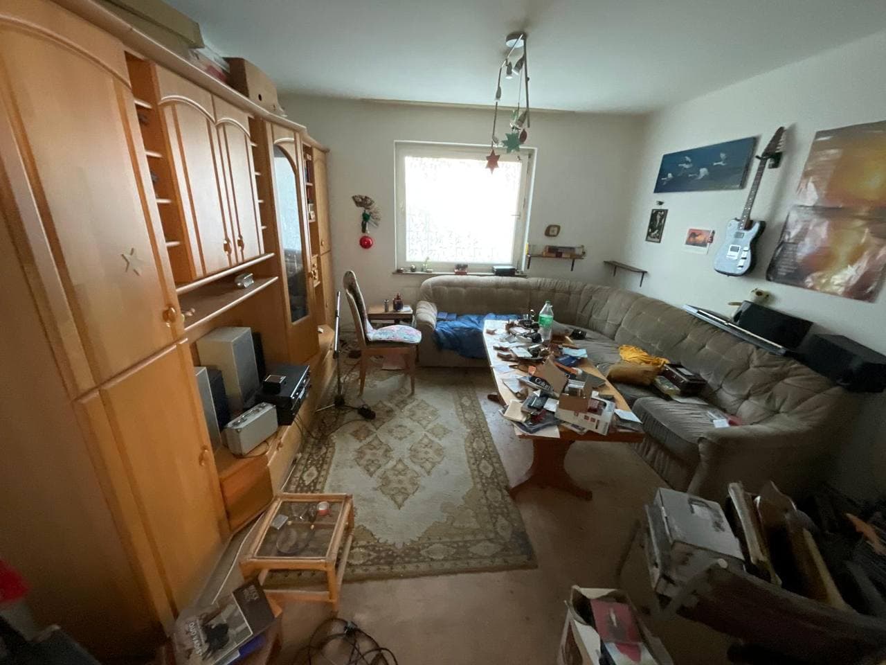 Wohnzimmer mit Schrankwand und Hausrat vor der Räumung